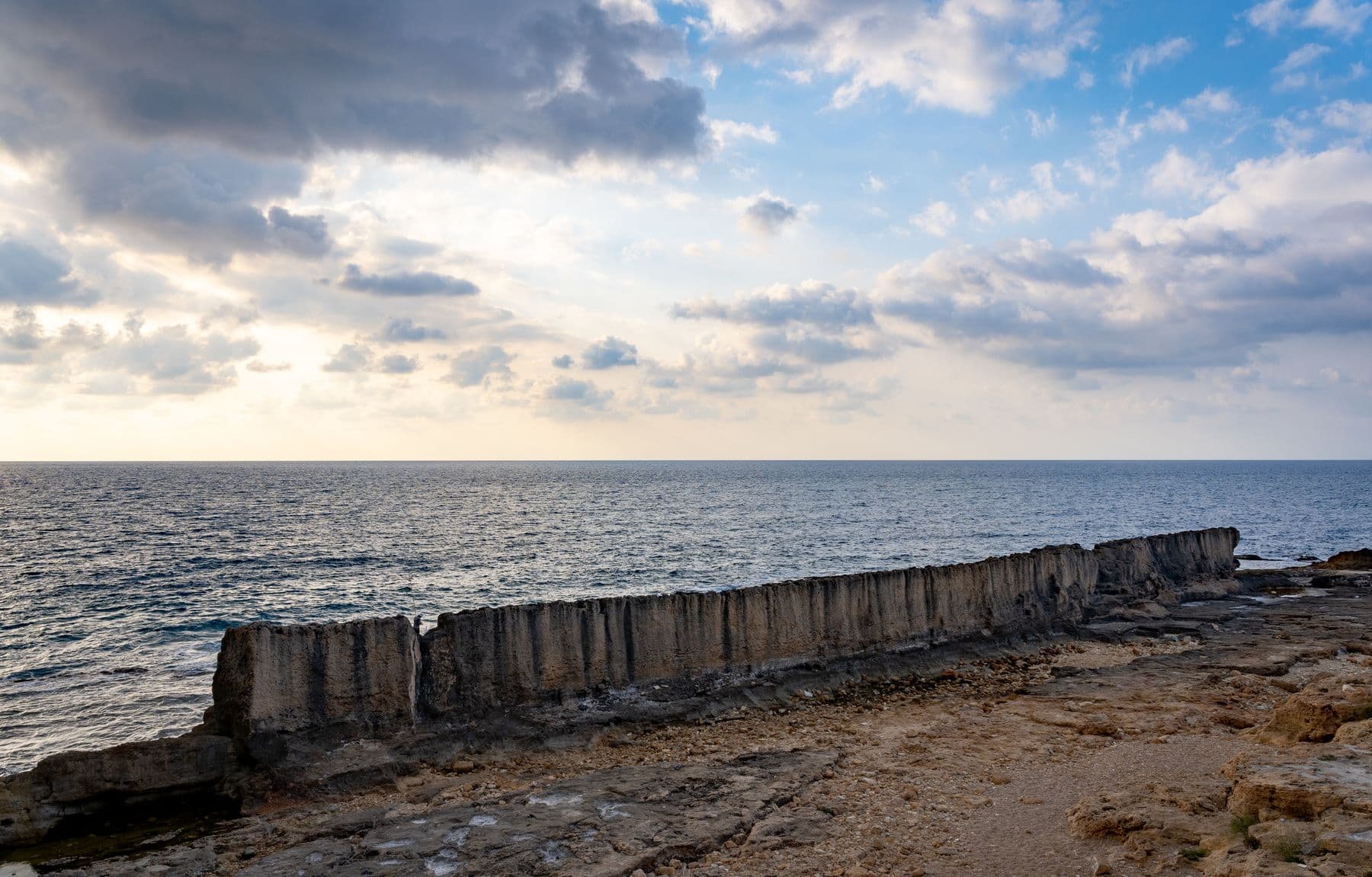 Sunset over the Mediterranean and the ancient Phoenician sea wall in Batroun